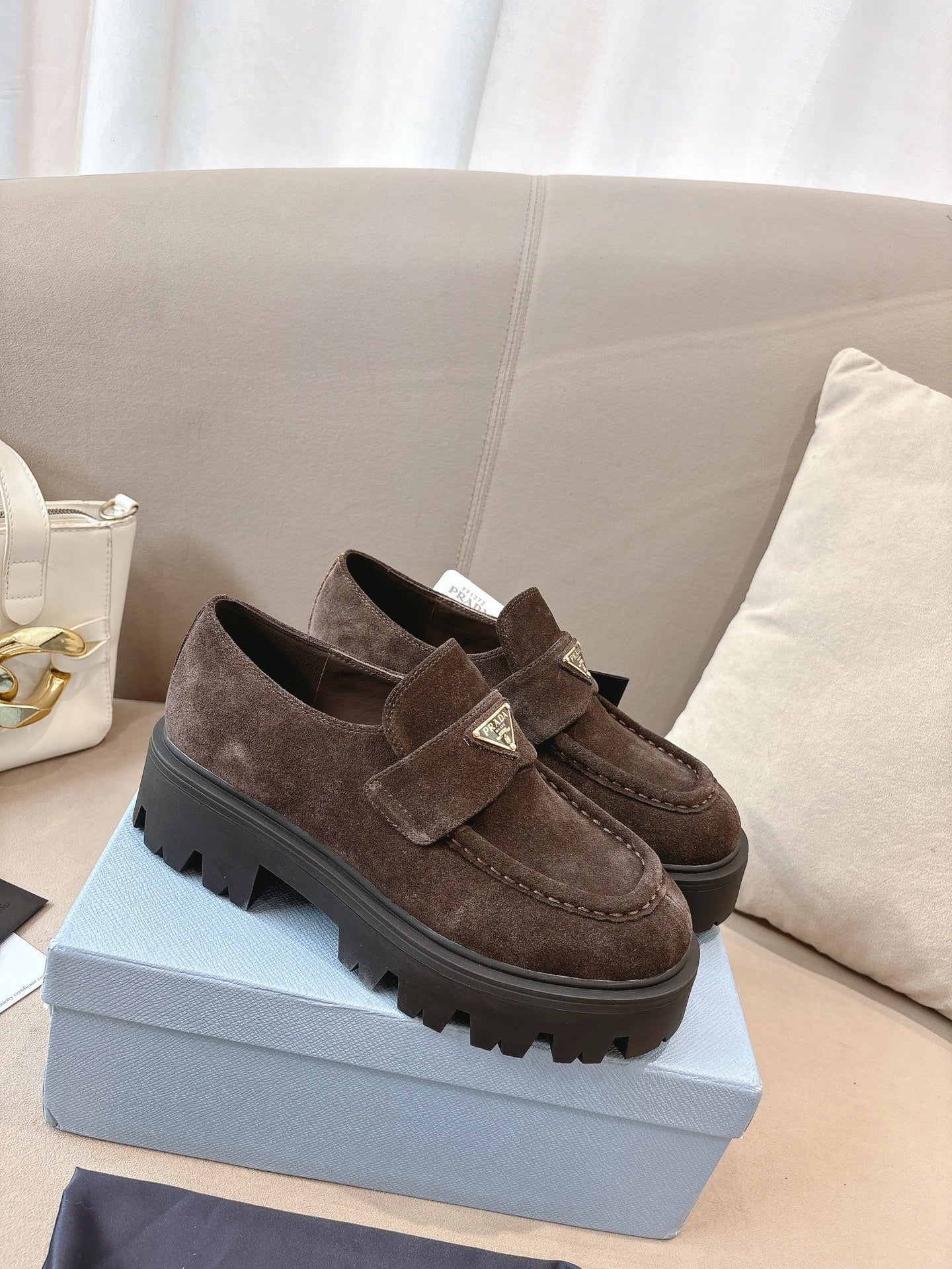 Dark brown suede loafers with buckled strap and squared, chunky lug sole