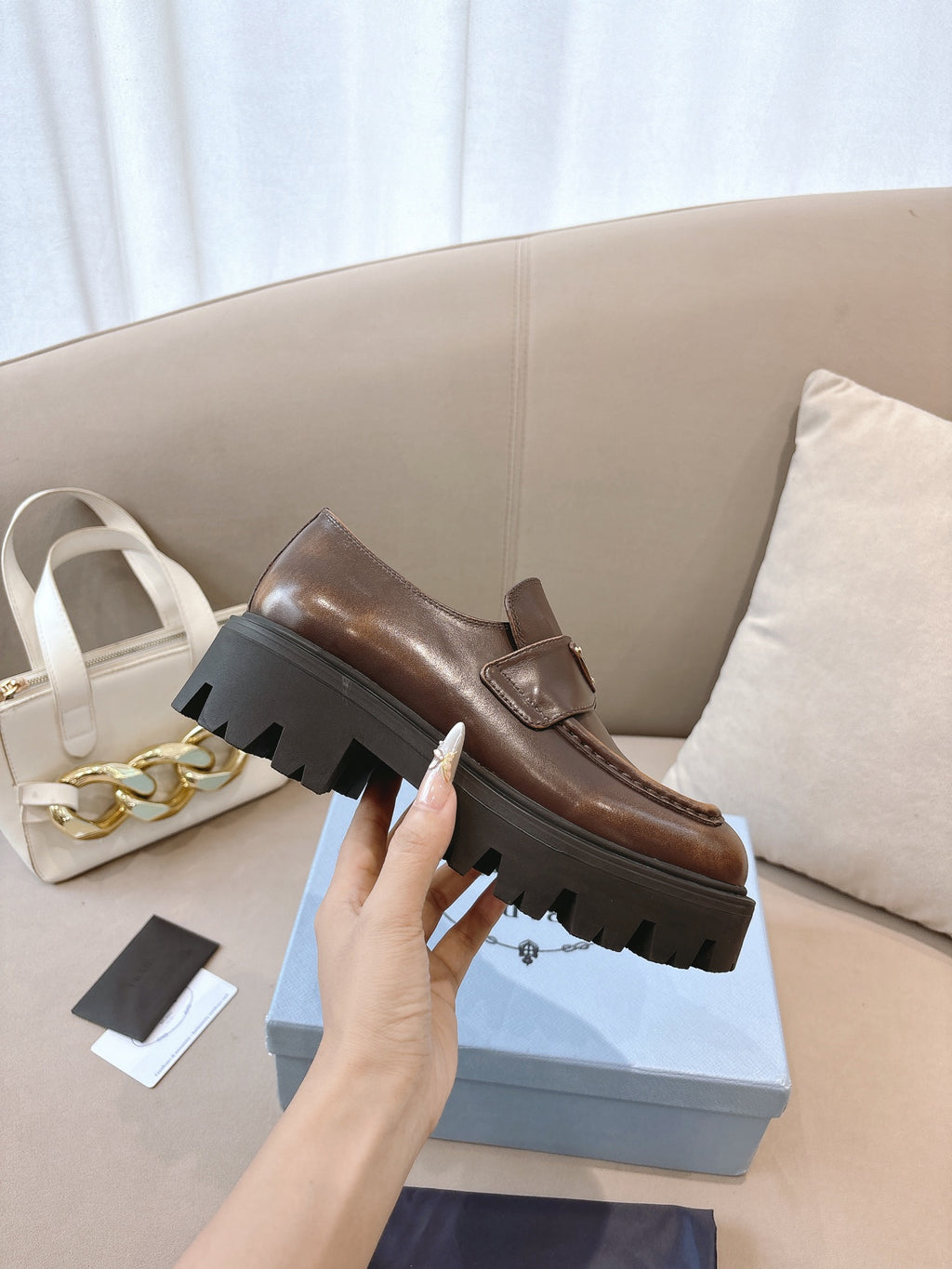 Prada ladies brown leather loafer, side view with platform lug sole and strap detail