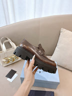 Prada ladies brown leather loafer, side view with platform lug sole and strap detail