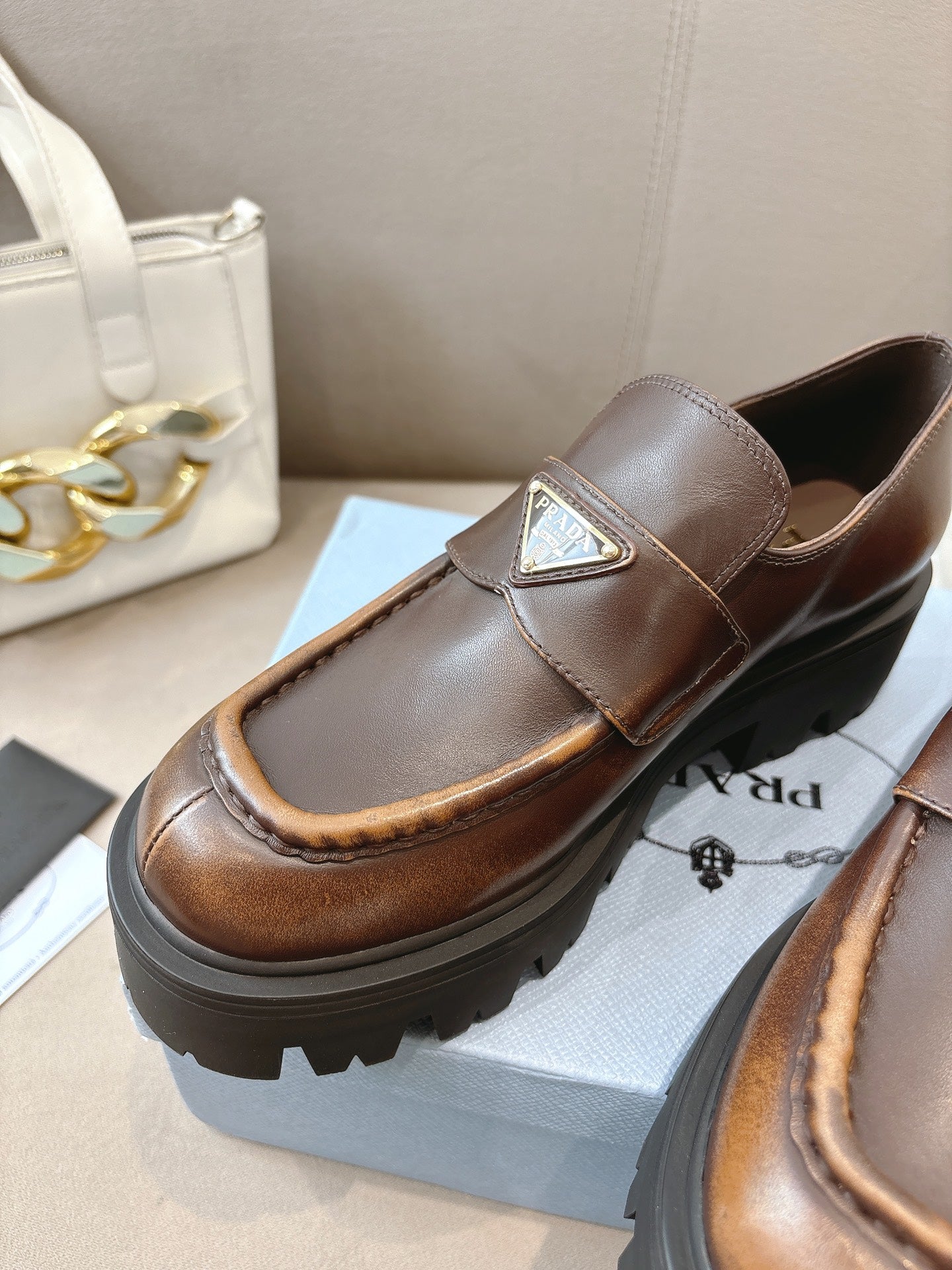 Prada ladies brown leather loafer with square logo plaque on strap and molded lug sole