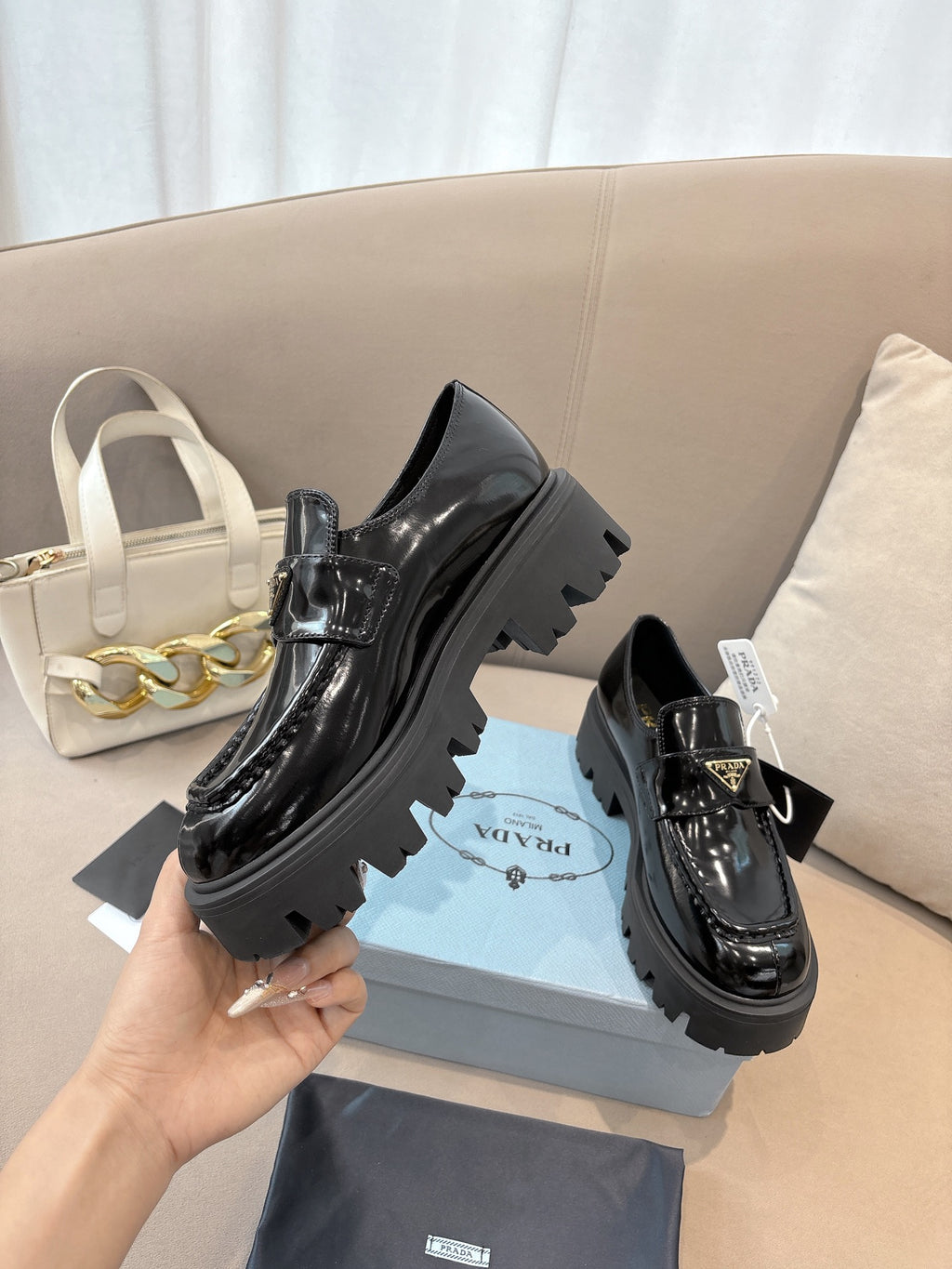 Prada ladies black patent loafers with front buckle and thick lug outsole, side view