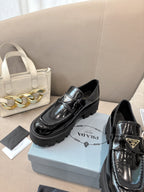 Prada ladies black patent loafer with buckle strap and low-profile platform sole
