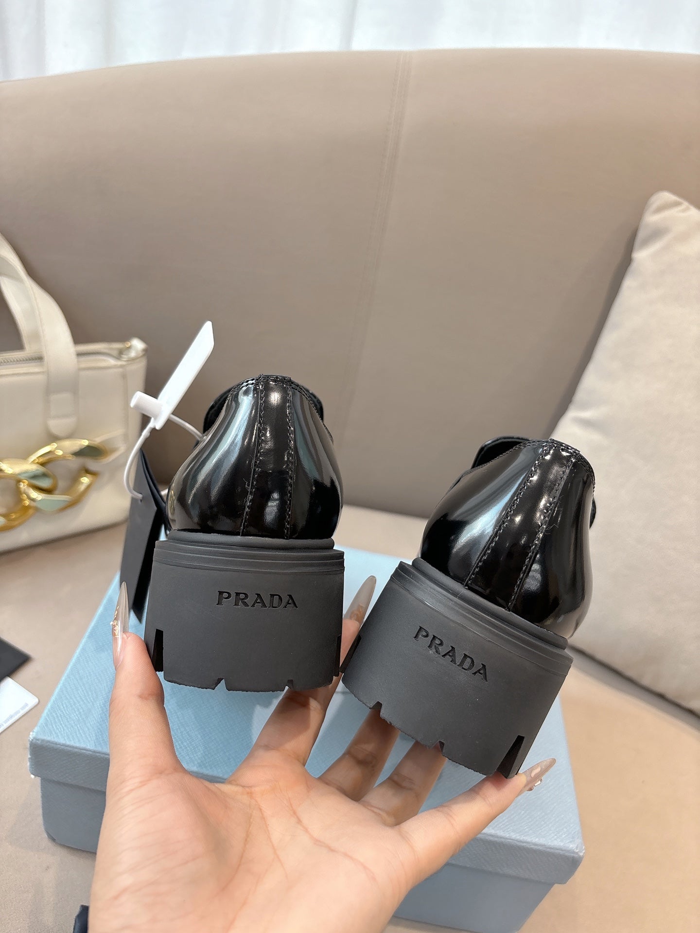 Prada ladies black patent loafers shown from heel and back, with chunky sole