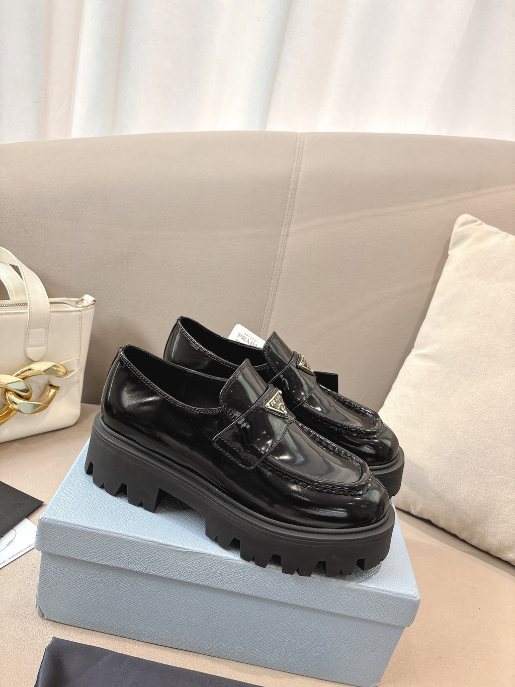 Prada ladies black patent loafers featuring front buckle and chunky treaded sole