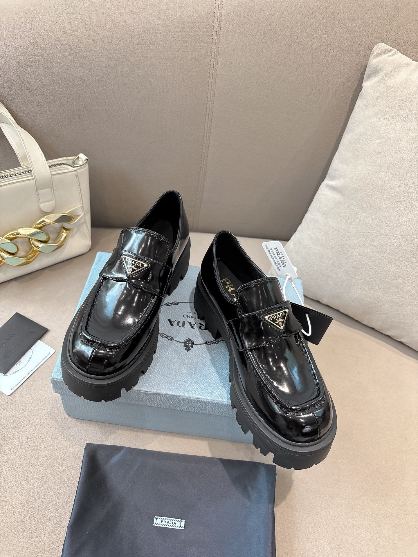 Prada ladies black patent loafers on display, with buckle strap and thick lug sole