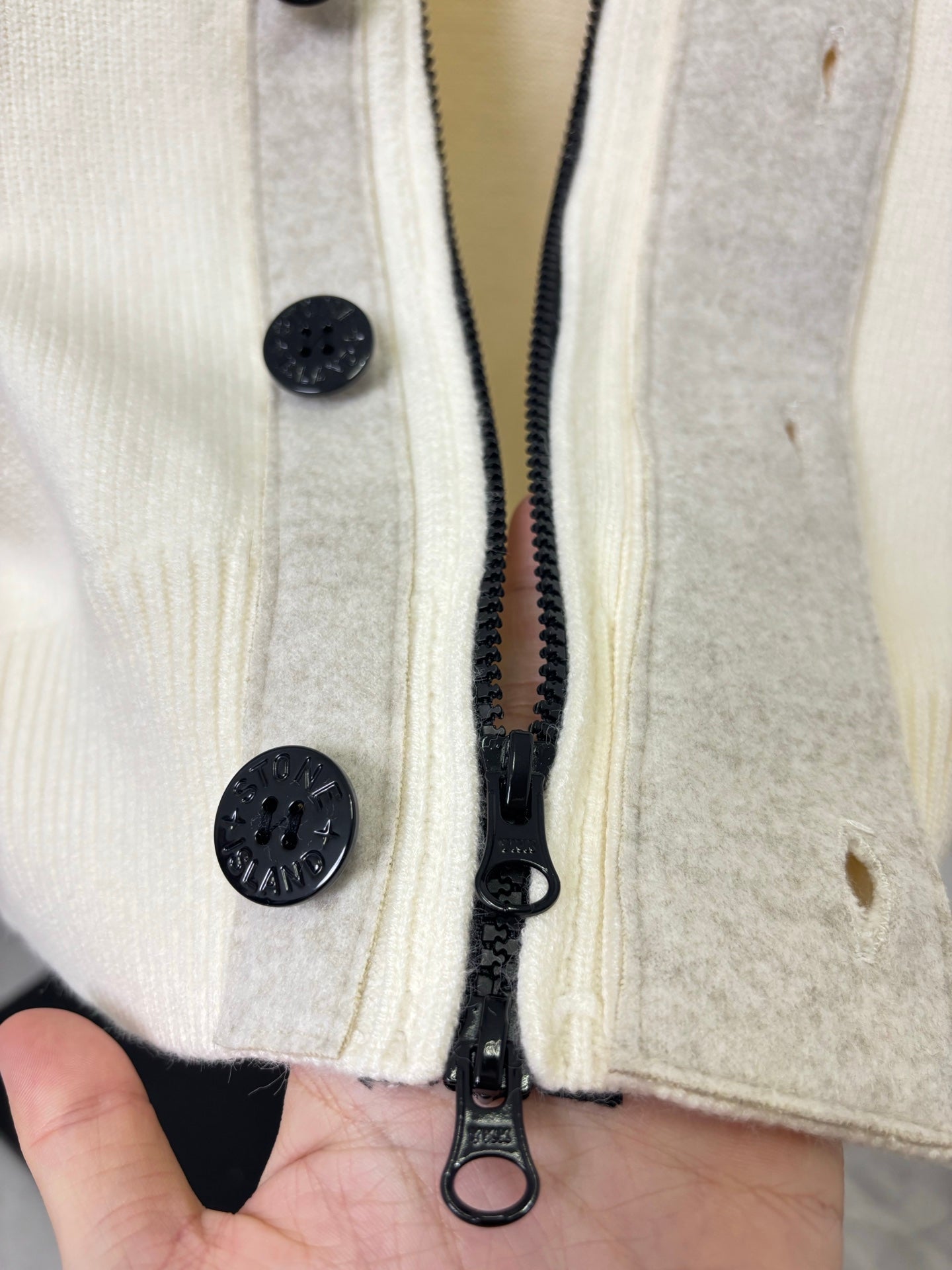 Stone Island knit cardigan button placket with zipper pull at inner seam