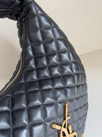 YSL quilted bag side close-up with gold zipper pull and hardware, dark