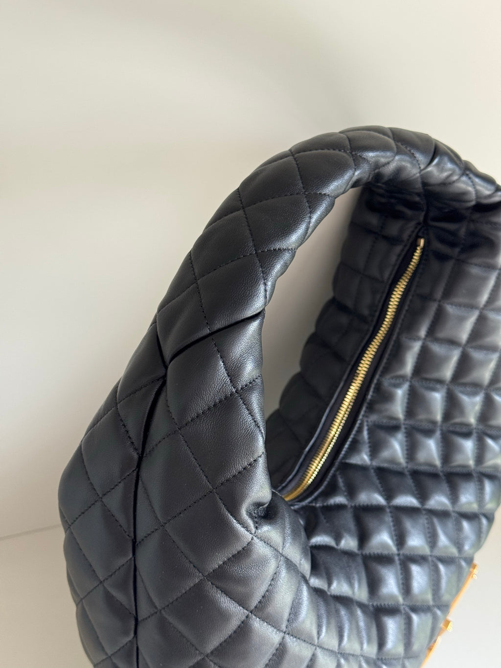 YSL quilted hobo bag side with gold-tone zipper and dark leather-look