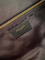 YSL logo label patch with gold zipper on dark quilted bag lining