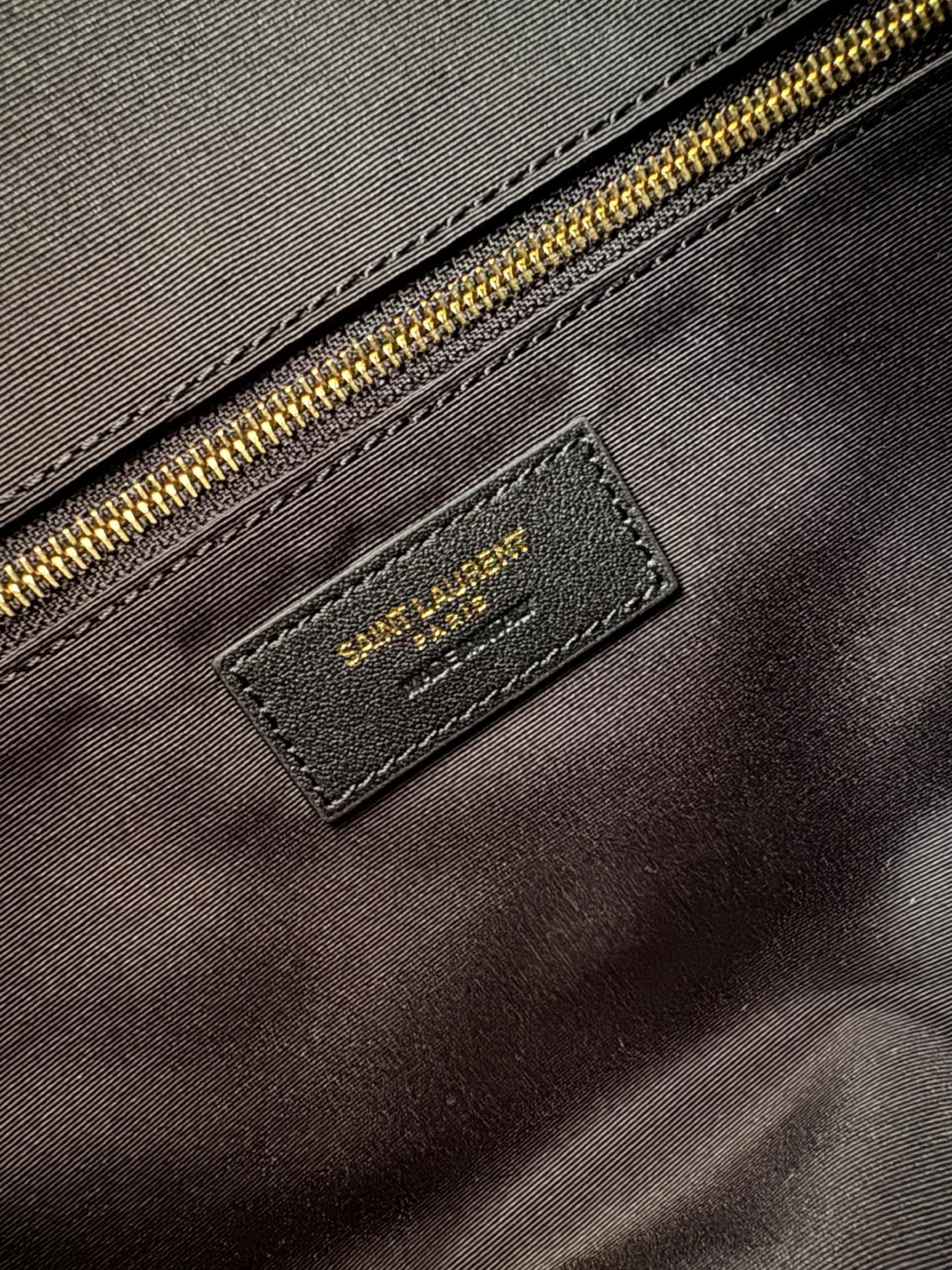 YSL logo label patch with gold zipper on dark quilted bag lining