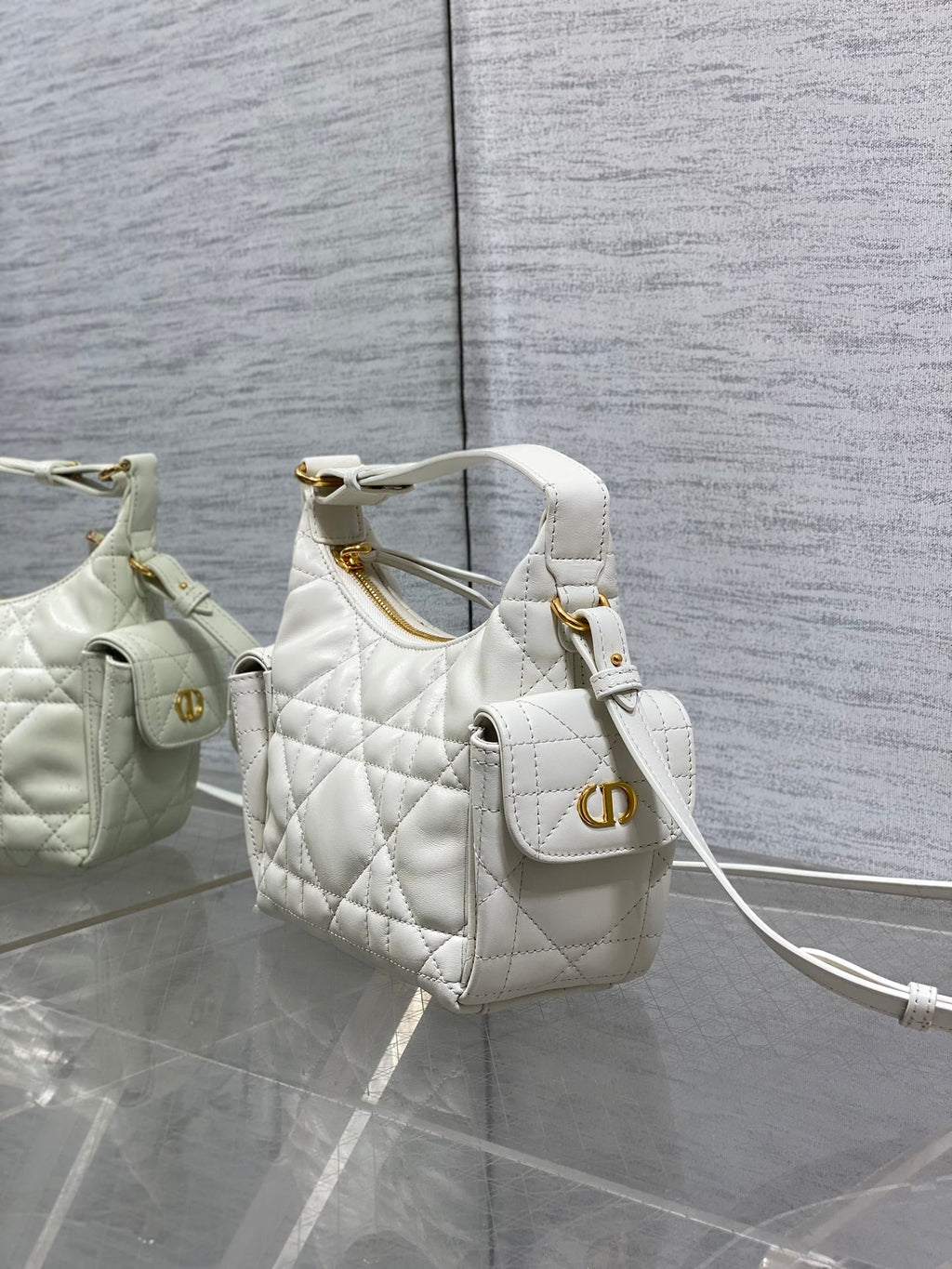 White quilted Dior mini shoulder bag with gold logo plate and adjustable crossbody strap.