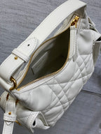 White Dior quilted crossbody bag showing gold zipper, interior pocket, and strap D-ring.