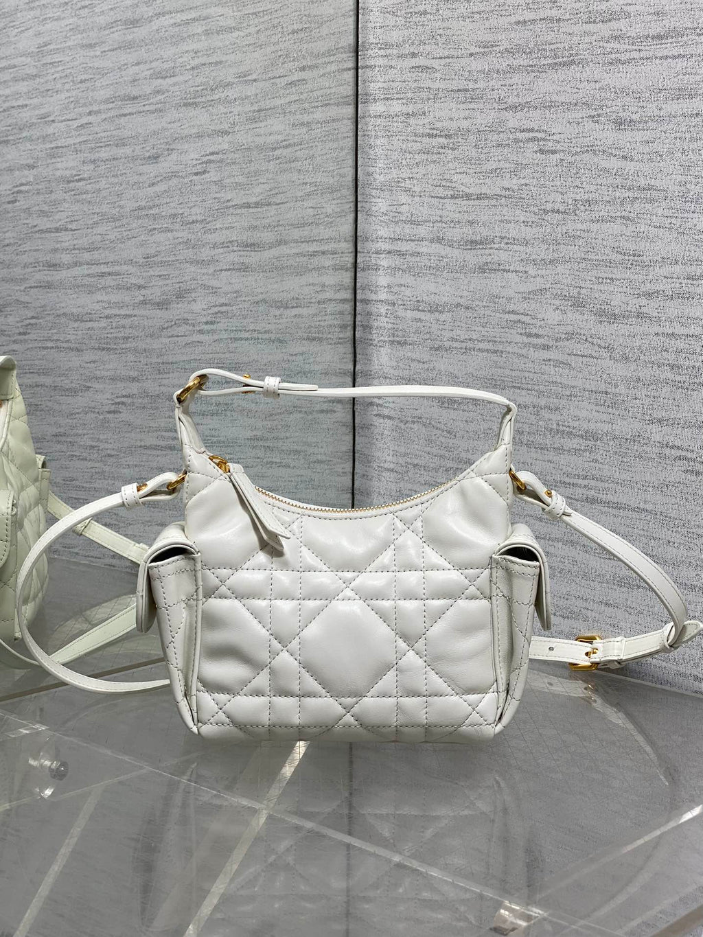 White quilted Dior shoulder bag with crossbody strap and gold-tone hardware, front view.