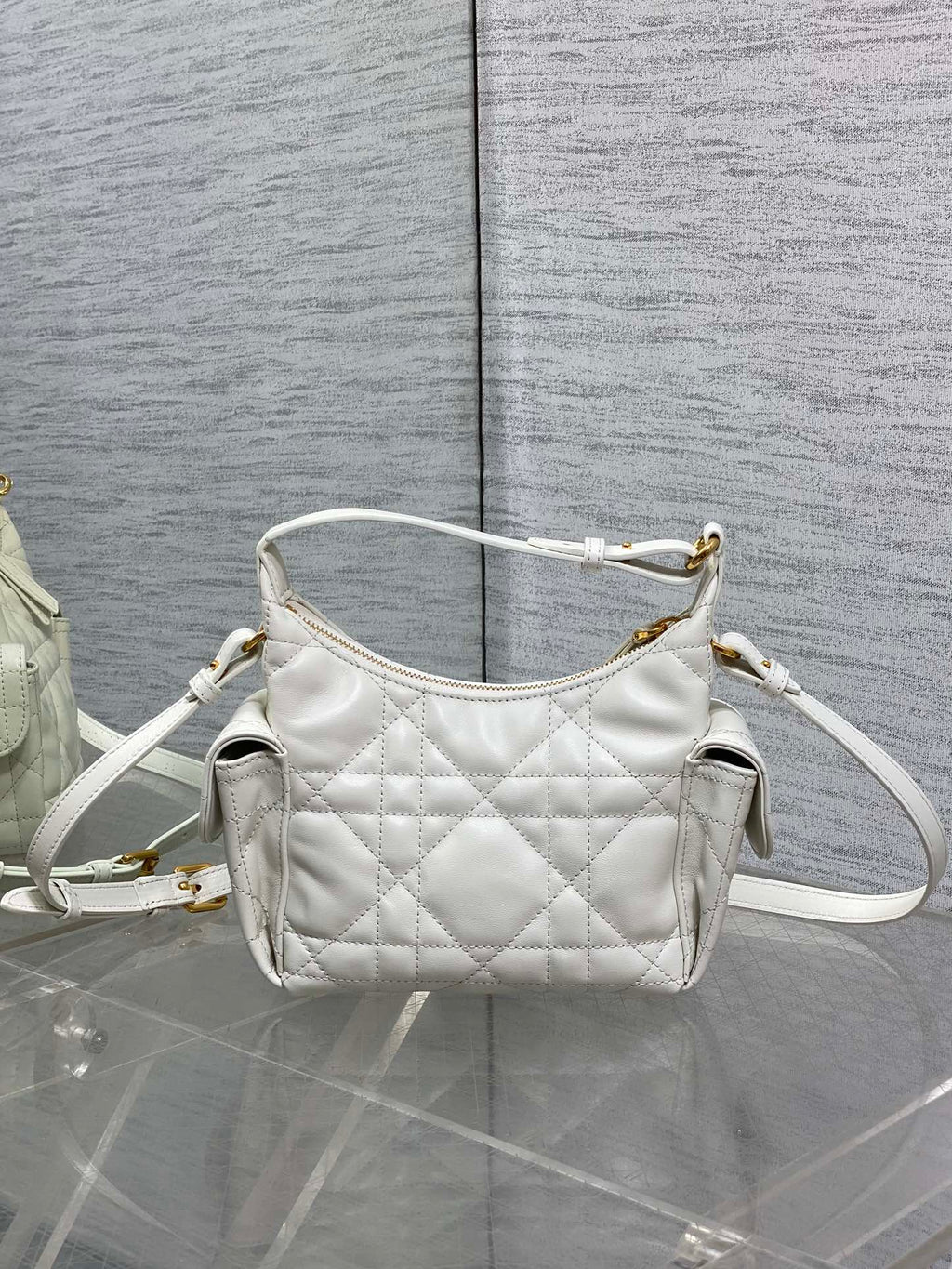White quilted Dior mini shoulder bag with long crossbody strap and gold top hardware.