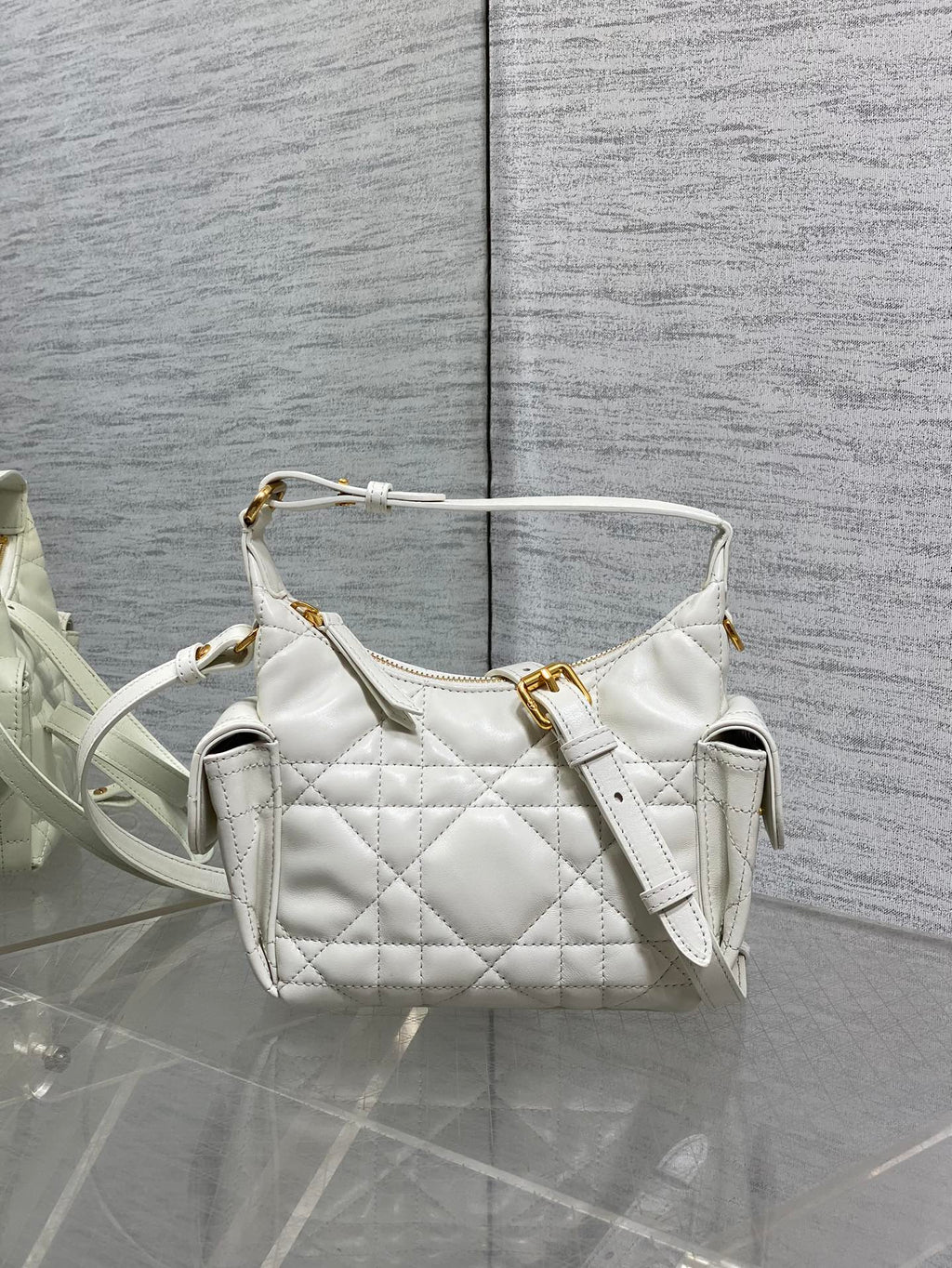 White quilted Dior shoulder bag with top handle and gold hardware, short strap.
