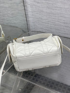 White Dior quilted shoulder bag with wide flap, top handle, and crossbody strap, side view.
