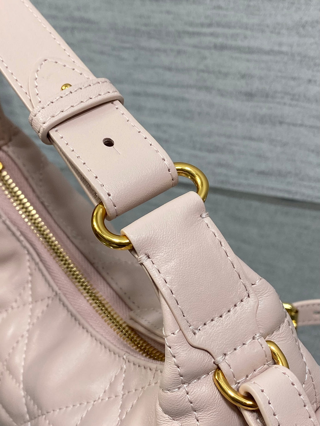 Dior light pink strap detail with gold rings and stitching over quilted bag body
