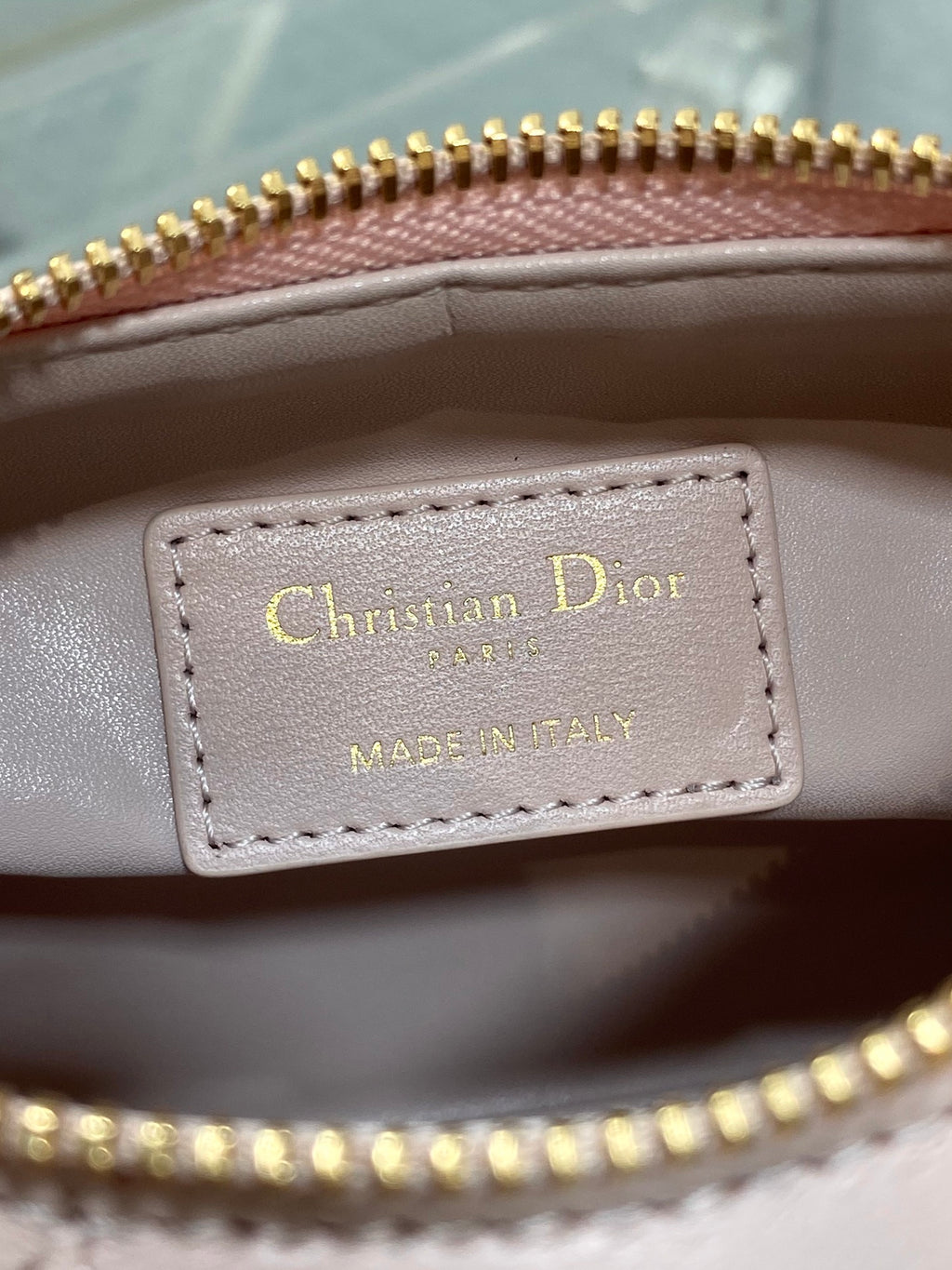 Christian Dior label inside Dior bag reading “MADE IN ITALY” with gold-printed text
