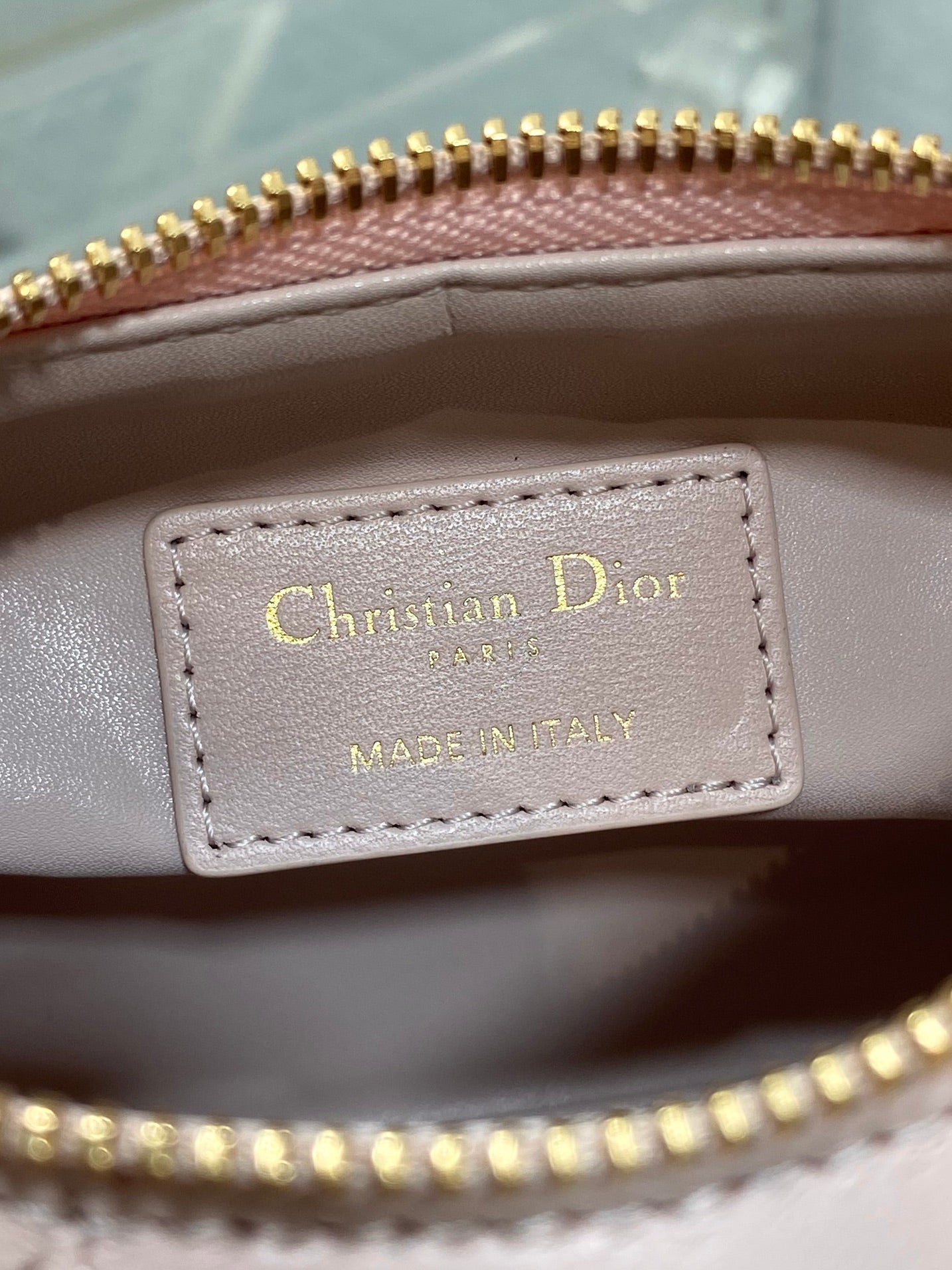 Christian Dior label inside Dior bag reading “MADE IN ITALY” with gold-printed text