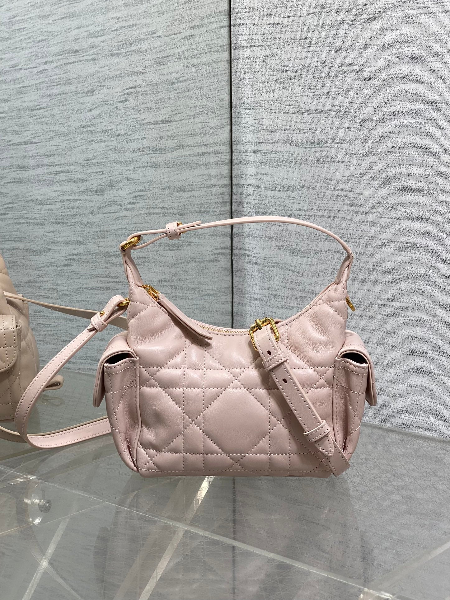 Dior quilted light pink hobo bag with top handle, crossbody strap, and gold hardware