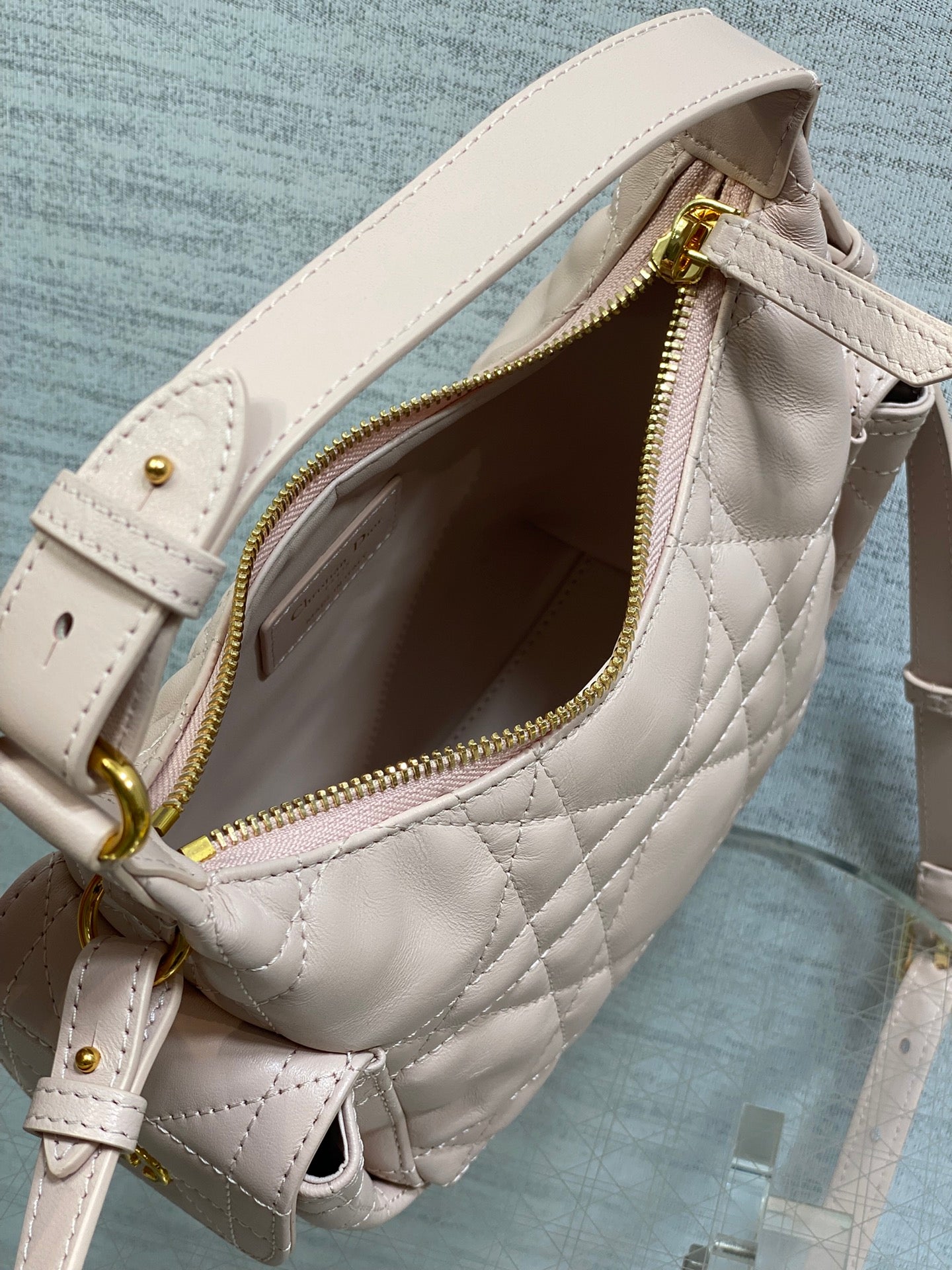 Dior light pink quilted bag with zipper opening and fabric-lined interior, gold zipper teeth