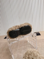 Balenciaga fuzzy beige slide sandals with black outsole, underside view on plastic