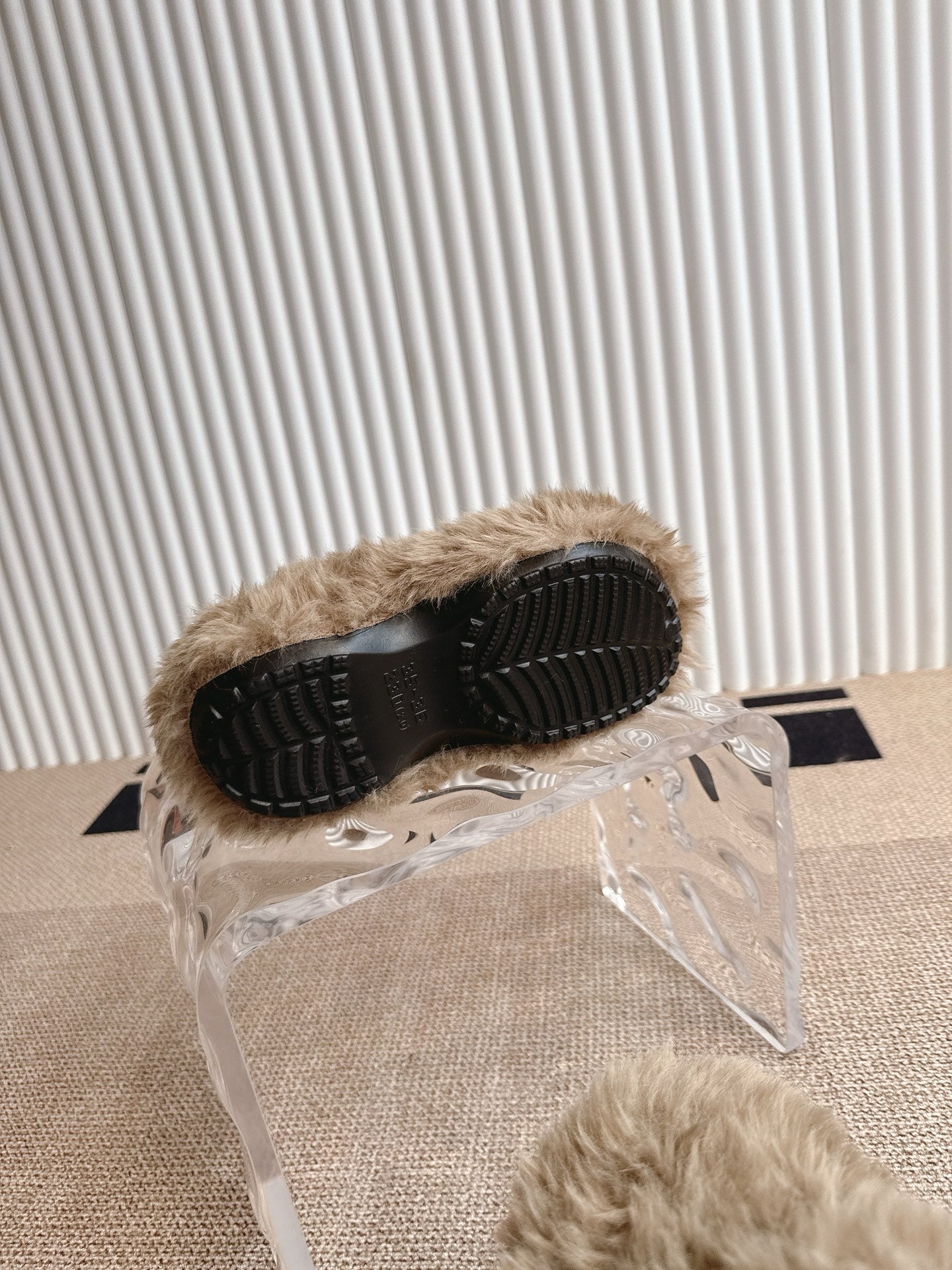 Balenciaga fuzzy beige slide sandals with black outsole, underside view on plastic