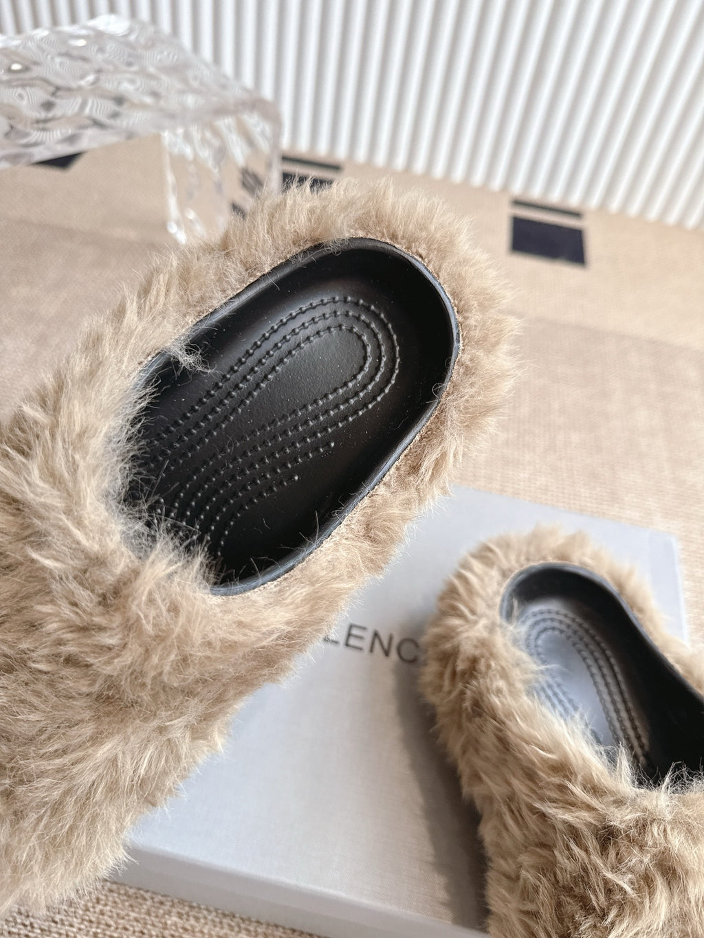 Balenciaga fuzzy beige slide sandal showing black perforated sole and edge