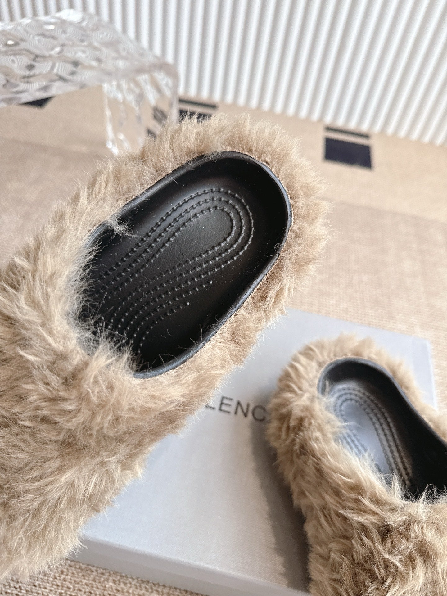 Balenciaga fuzzy beige slide sandal showing black perforated sole and edge