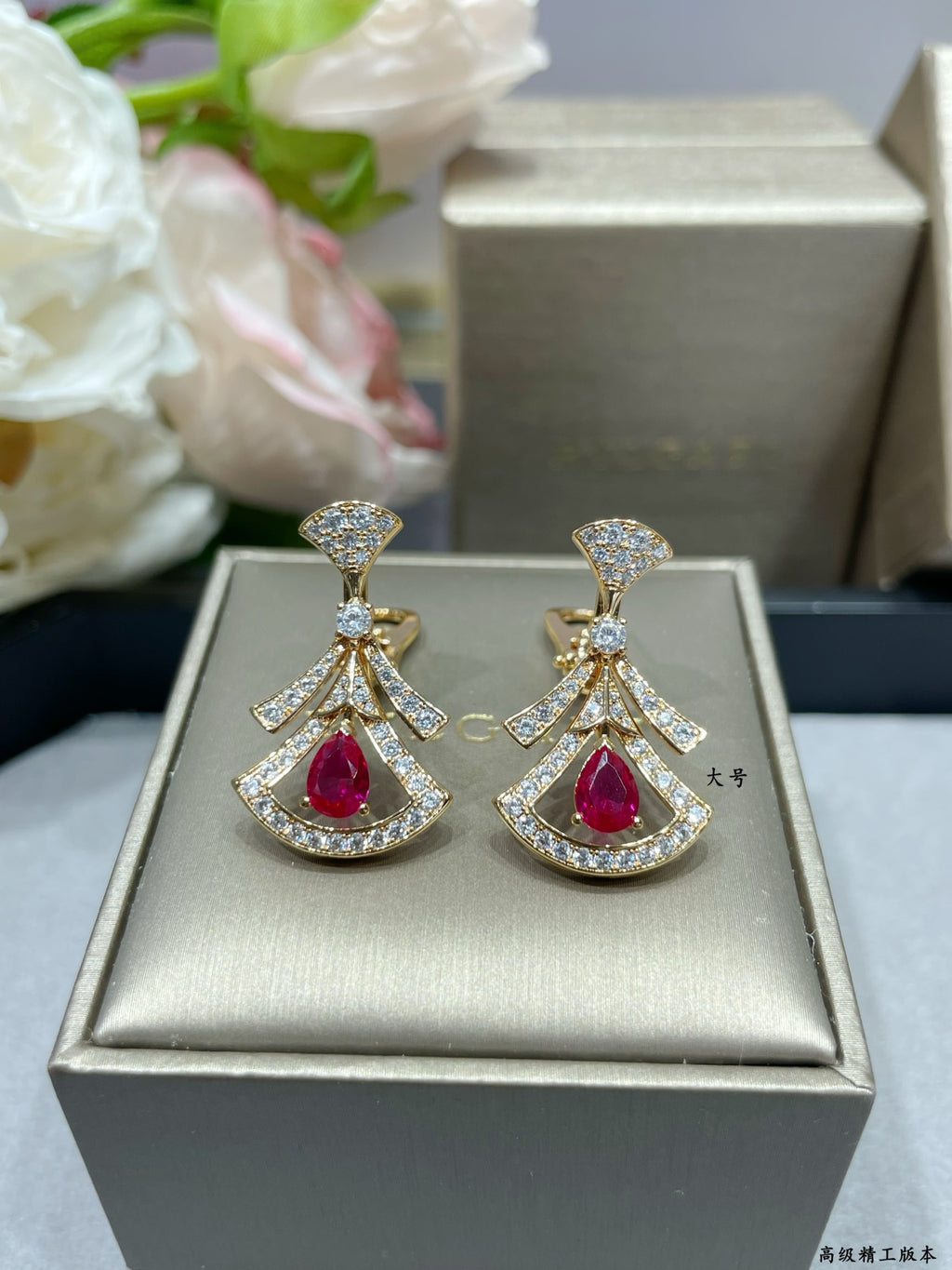 Pair of dangling drop earrings in gift box, red gemstone teardrops with gold pavé.