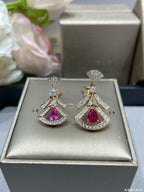 Dangling drop earrings in jewelry box, red teardrop gemstones with diamond-like pavé.