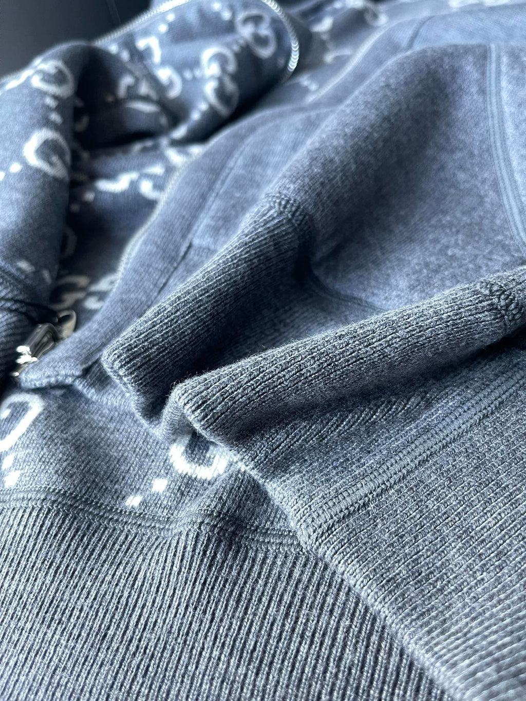 Gucci hoodie fabric close-up with gray knit texture and ribbed cuff detail