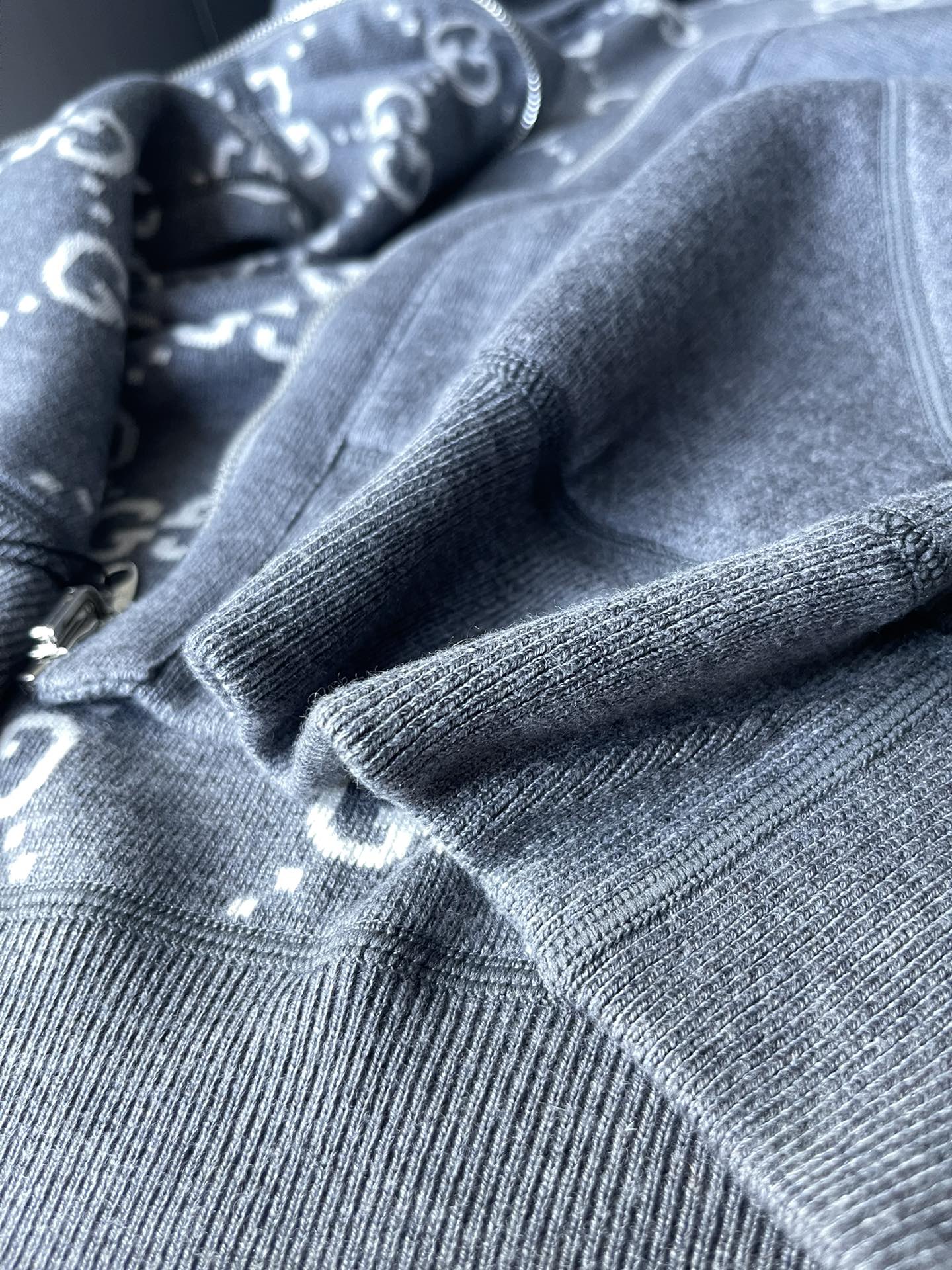 Gucci hoodie fabric close-up with gray knit texture and ribbed cuff detail