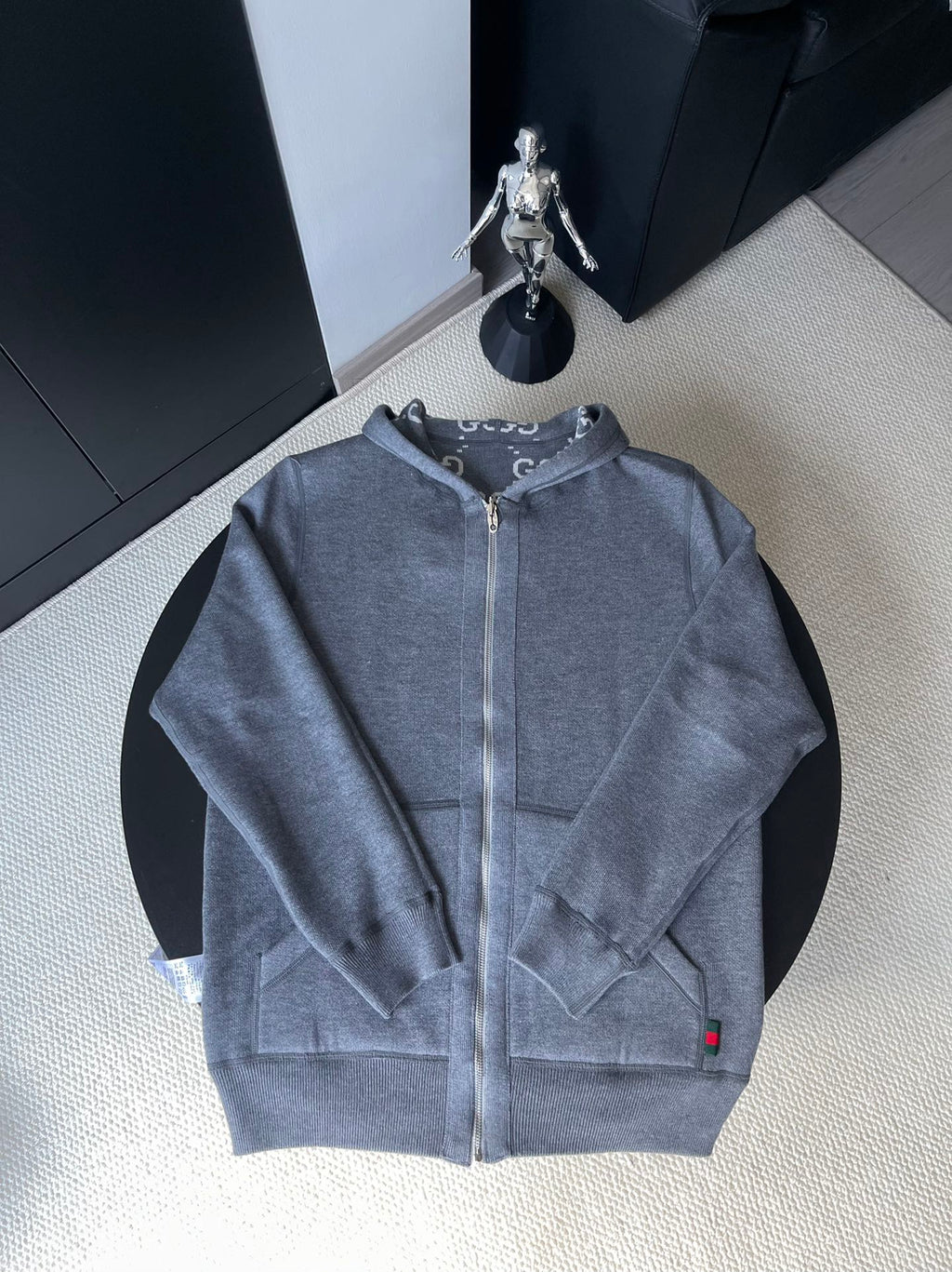 Gucci zip-up hoodie in medium blue-gray with hood, front zipper, and small red logo tab