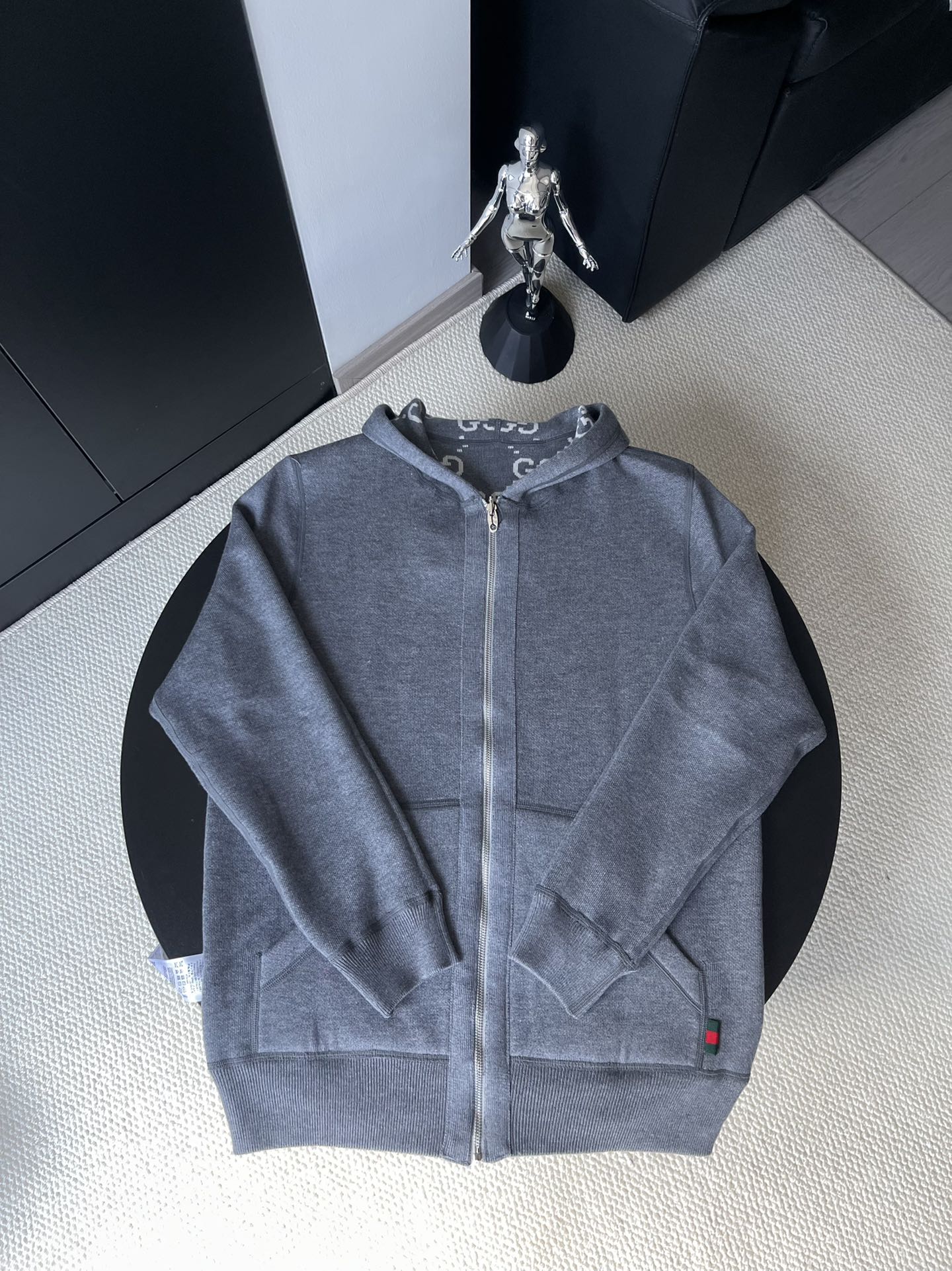 Gucci zip-up hoodie in medium blue-gray with hood, front zipper, and small red logo tab