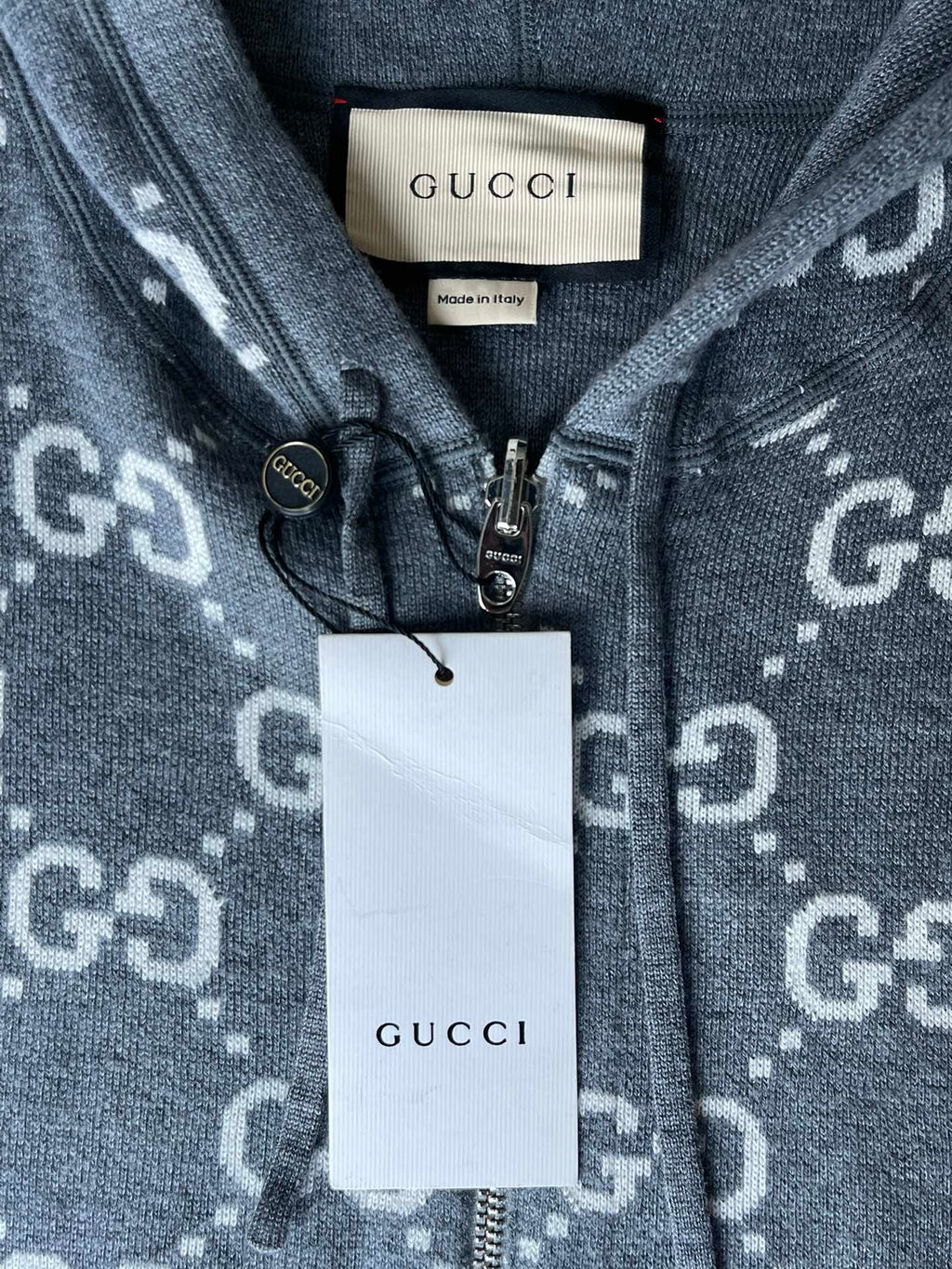 Gucci zip-up hoodie neckline close-up with GUCCI tag and front zipper hardware