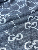 Close-up of Gucci GG logo pattern knit on dark gray zip-up hoodie fabric