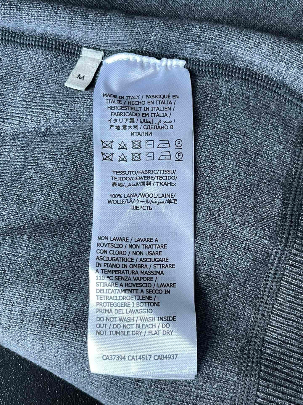 Inside size label on Gucci zip-up hoodie fabric, with care and fabric details
