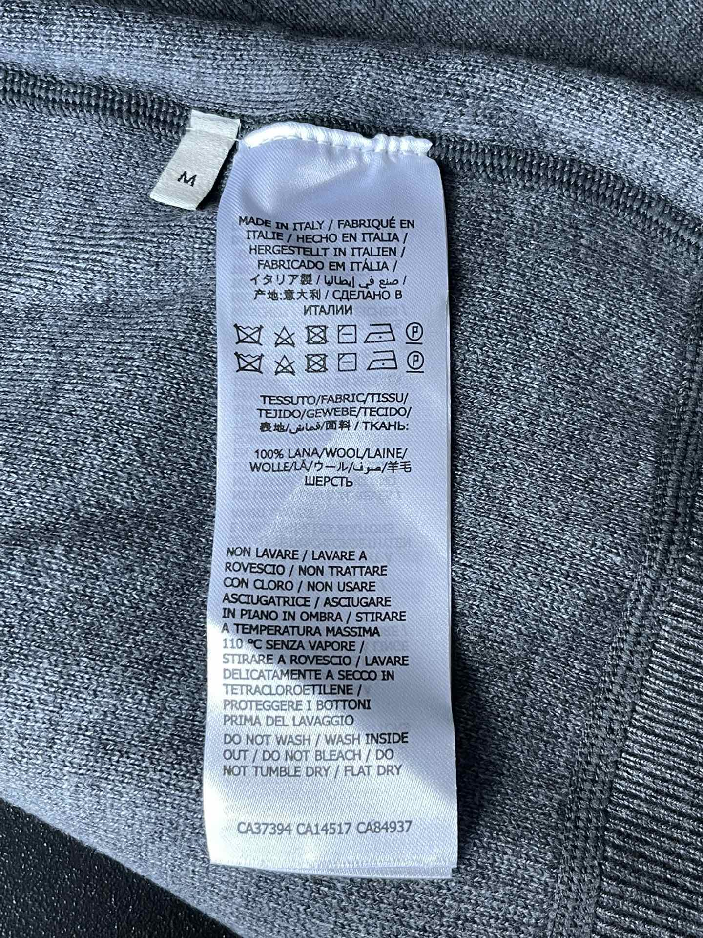 Inside size label on Gucci zip-up hoodie fabric, with care and fabric details