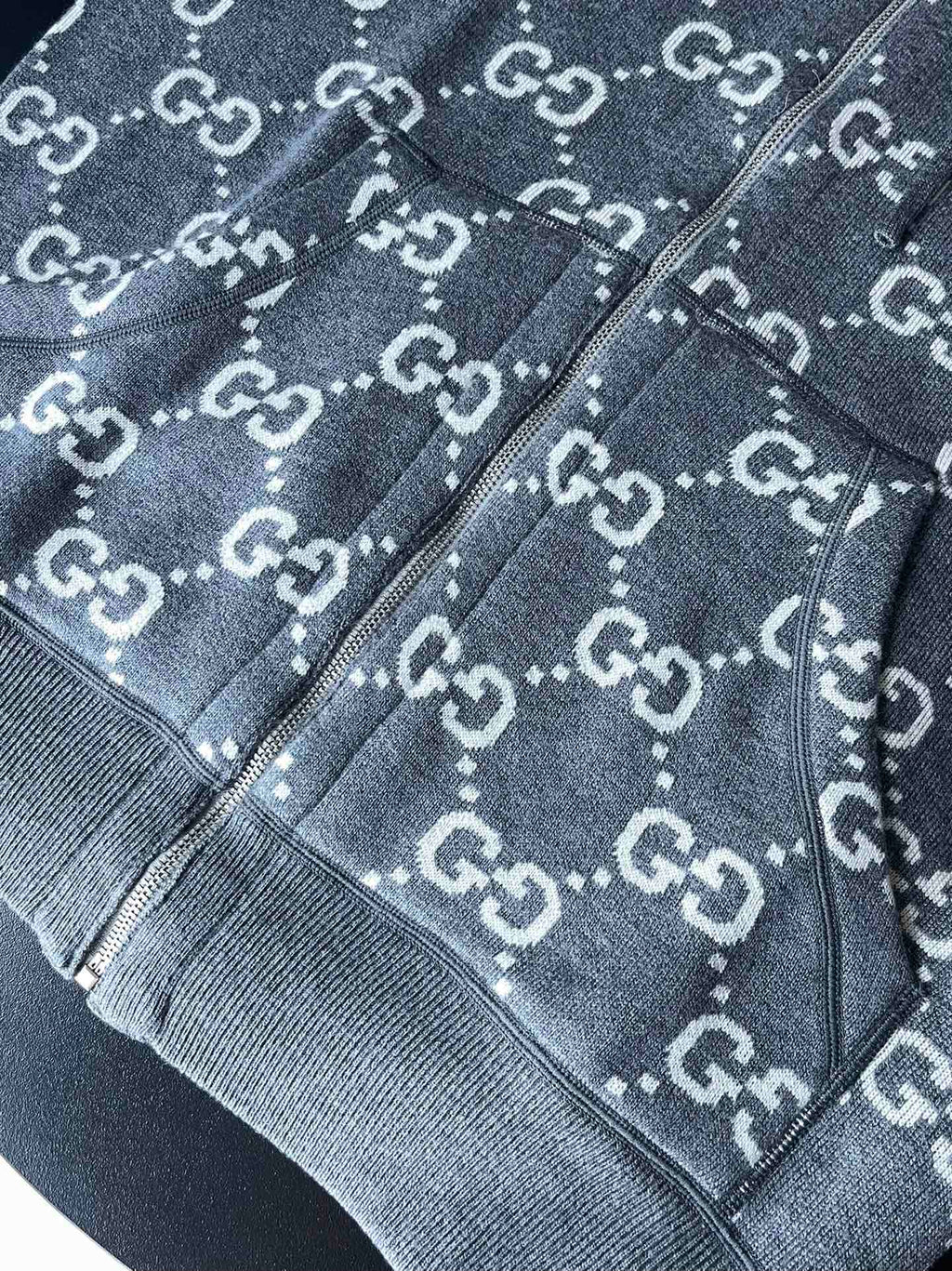Gucci GG logo zip-up hoodie close-up showing zipper trim and drawcord hood edge