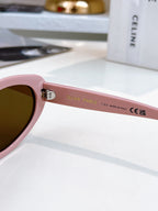 Sunglasses with pink frame and brown-tinted lenses, side view