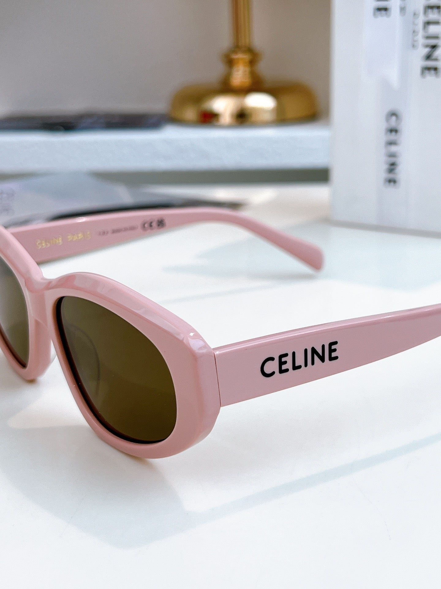 Pink Celine sunglasses with dark brown tinted lenses and logo on temple