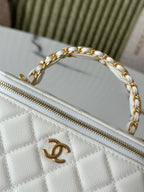 White quilted mini handbag close-up of gold zipper and chain strap ring.