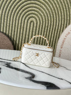 White quilted mini handbag with gold chain strap and top handle, front view.