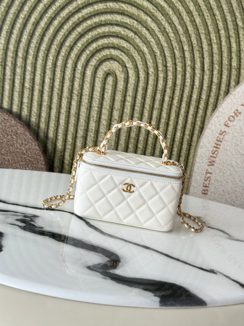 White quilted mini handbag with gold chain strap and top handle, front view.