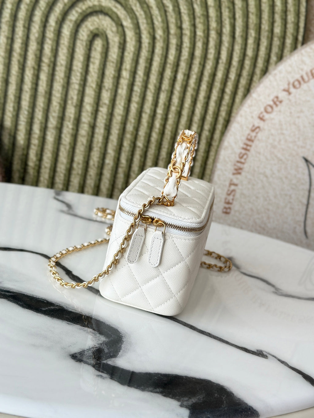White quilted mini handbag with gold chain strap and small flap, side angle.