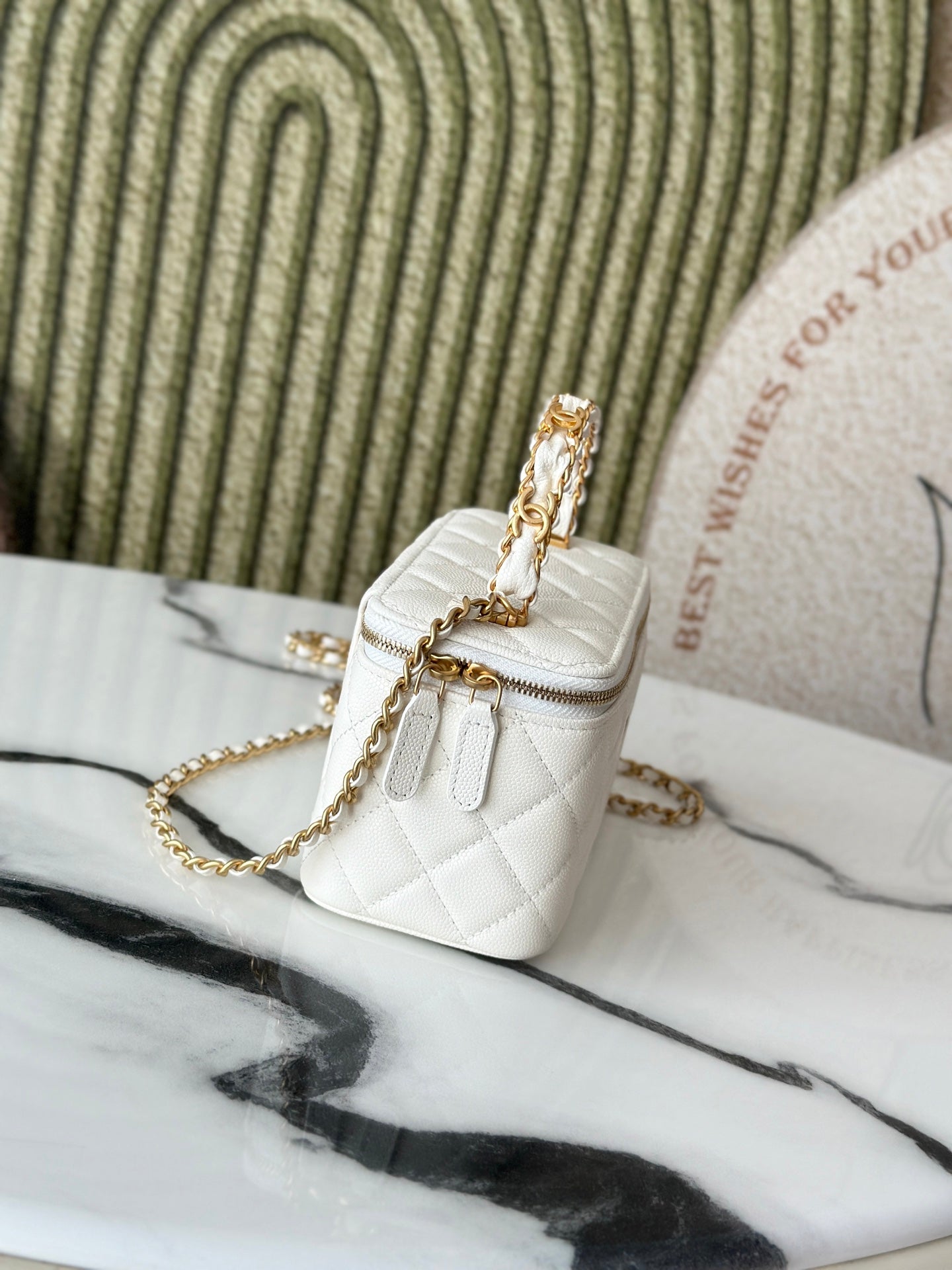 White quilted mini handbag with gold chain strap and small flap, side angle.