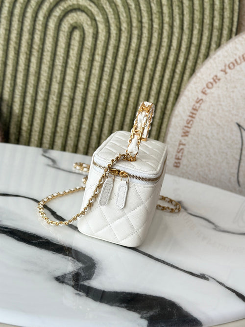 White quilted mini handbag with gold chain strap and small flap, side angle.