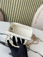 White mini handbag interior view with cream lining and gold zipper trim.