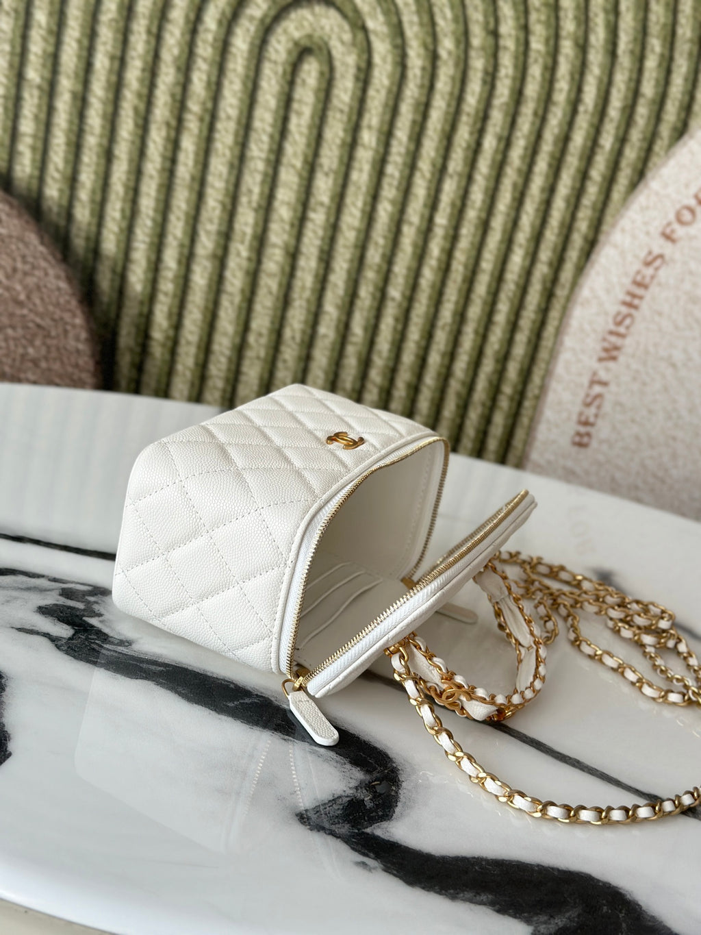 White quilted mini handbag side view with gold zipper and gold chain strap.